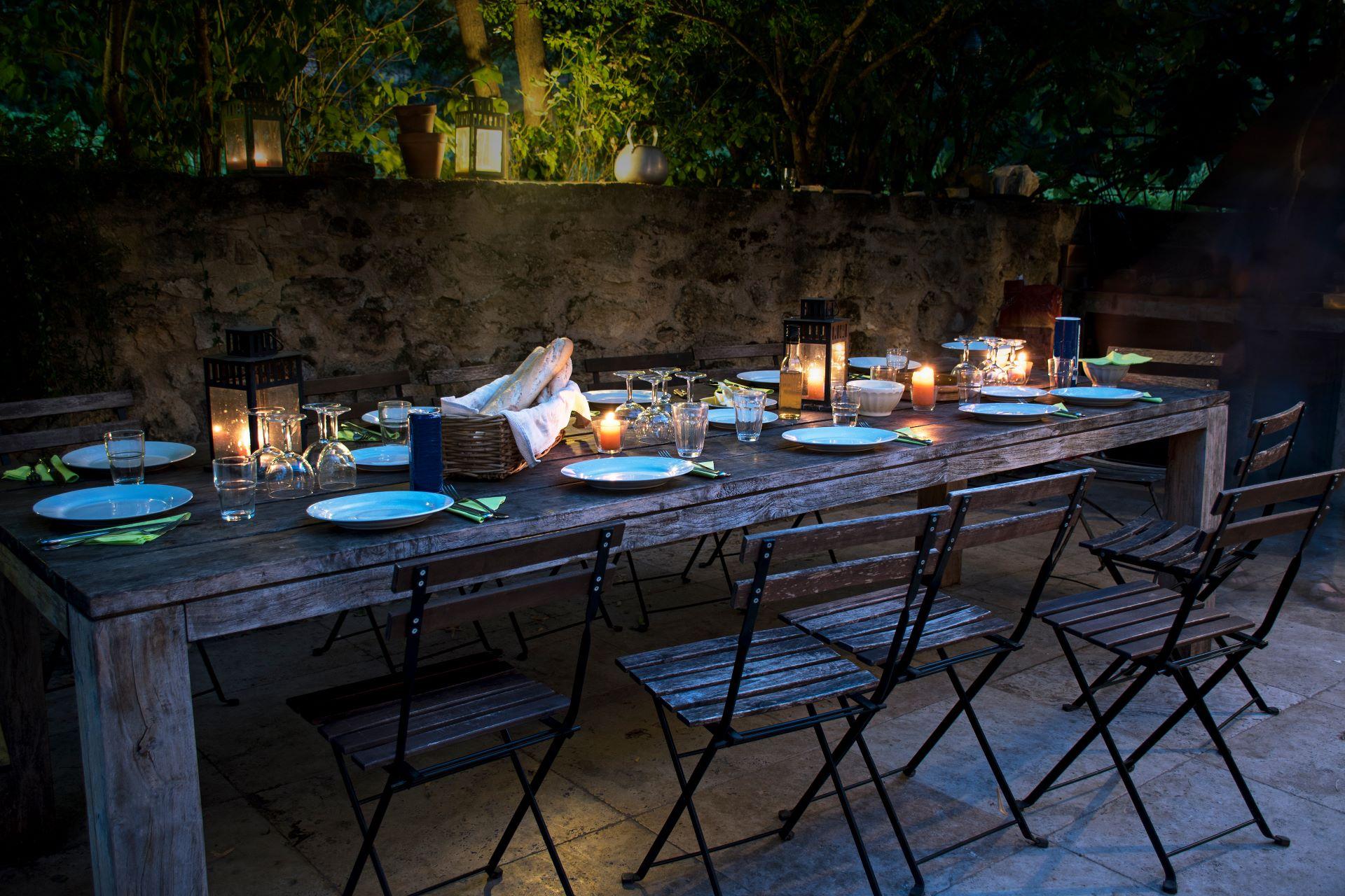 großer rustikaler Tisch für ein abendliches Essen im Freien