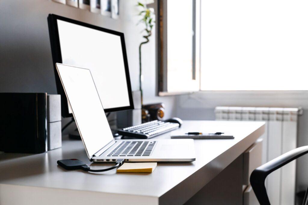 Home-Office mit modernem Laptop und ergonomischer Ausstattung, ideal beleuchtet durch Tageslicht und gestaltet mit einer Zimmertür weiß.