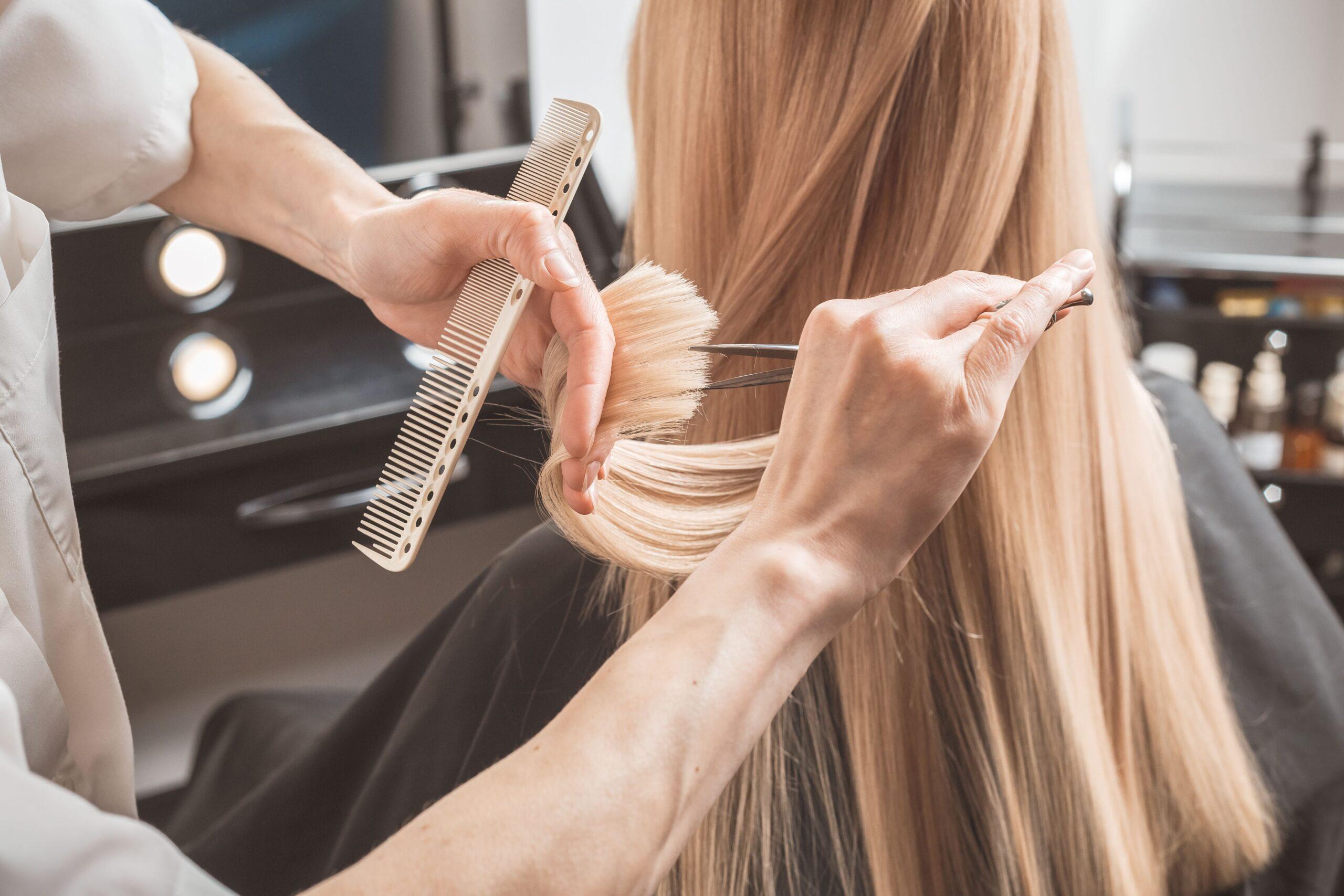 Eine Frau beim Spitzen schneiden beim Friseur