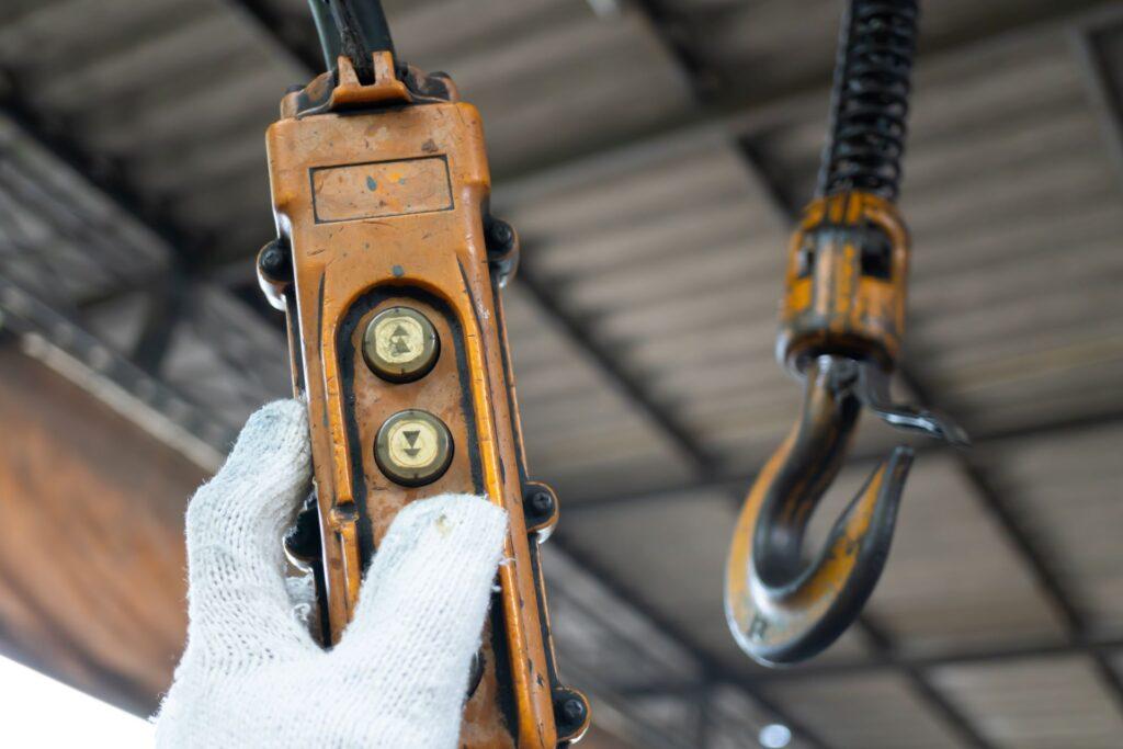 Nahaufnahme eines Elektrokettenzug-Hakens mit Bedienfeld.