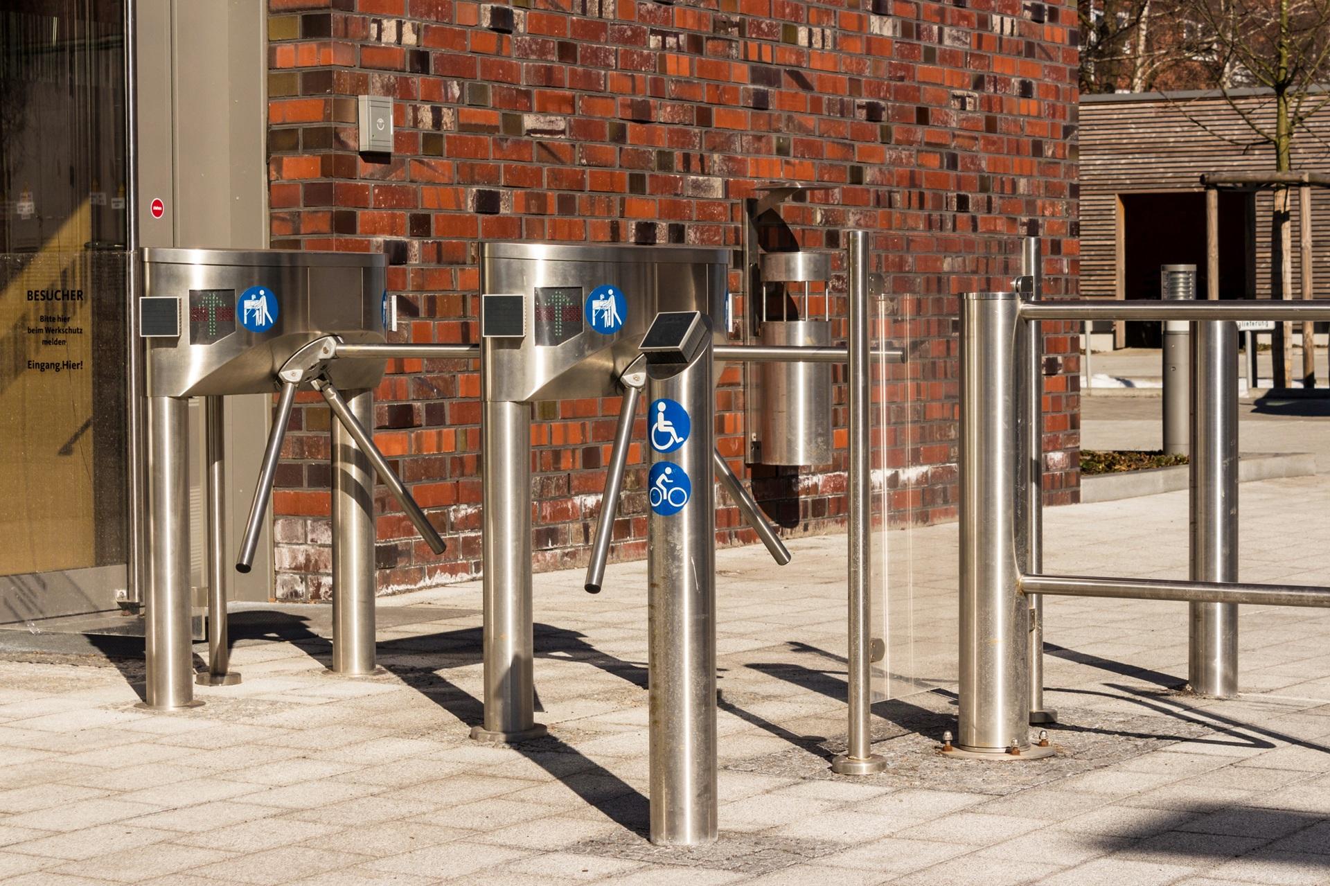 Metallisches Drehkreuz vor Backsteinwand | Absperrpfosten
