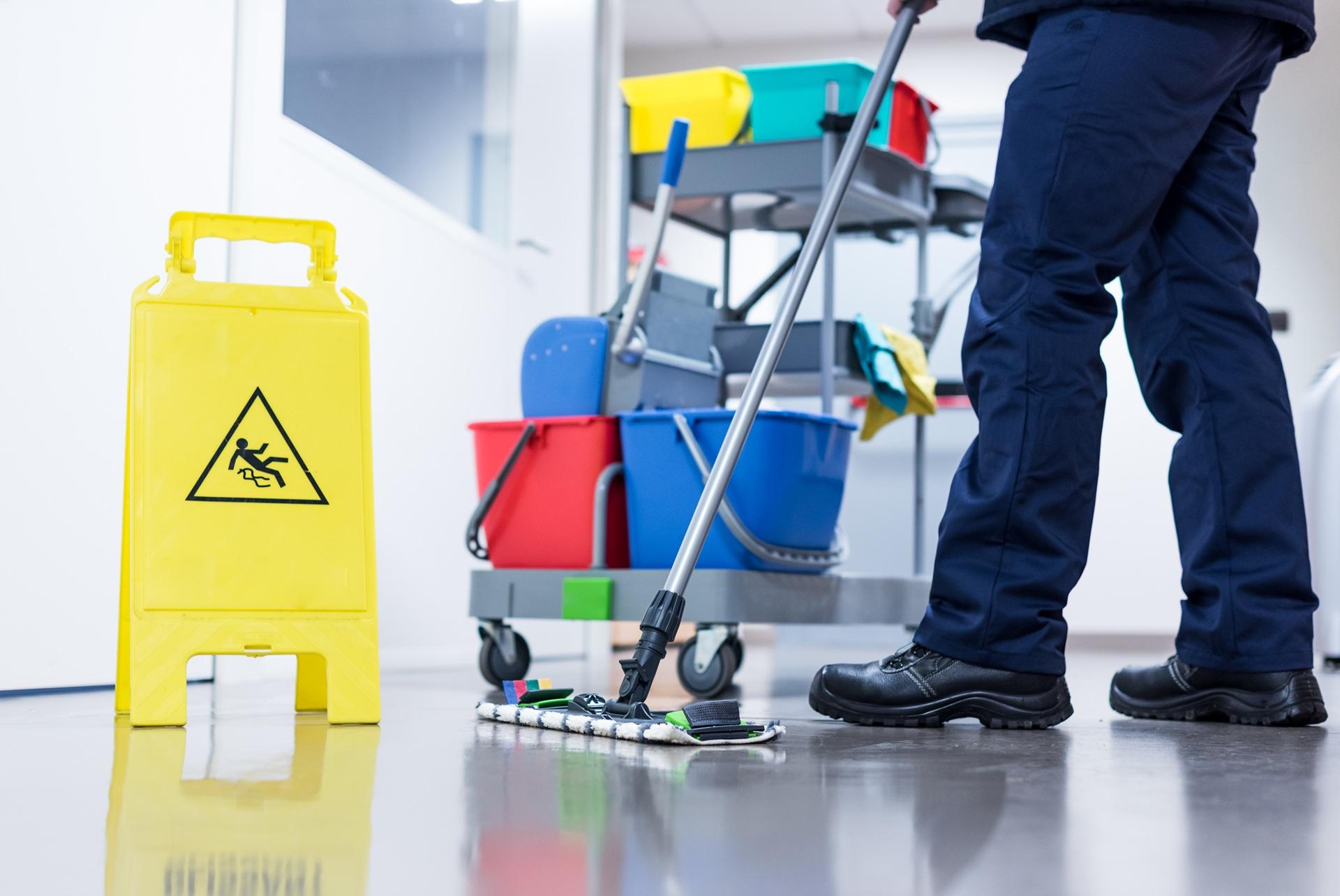 Nassreinigung im Flur mit Warnschild | Gebäudereinigung

