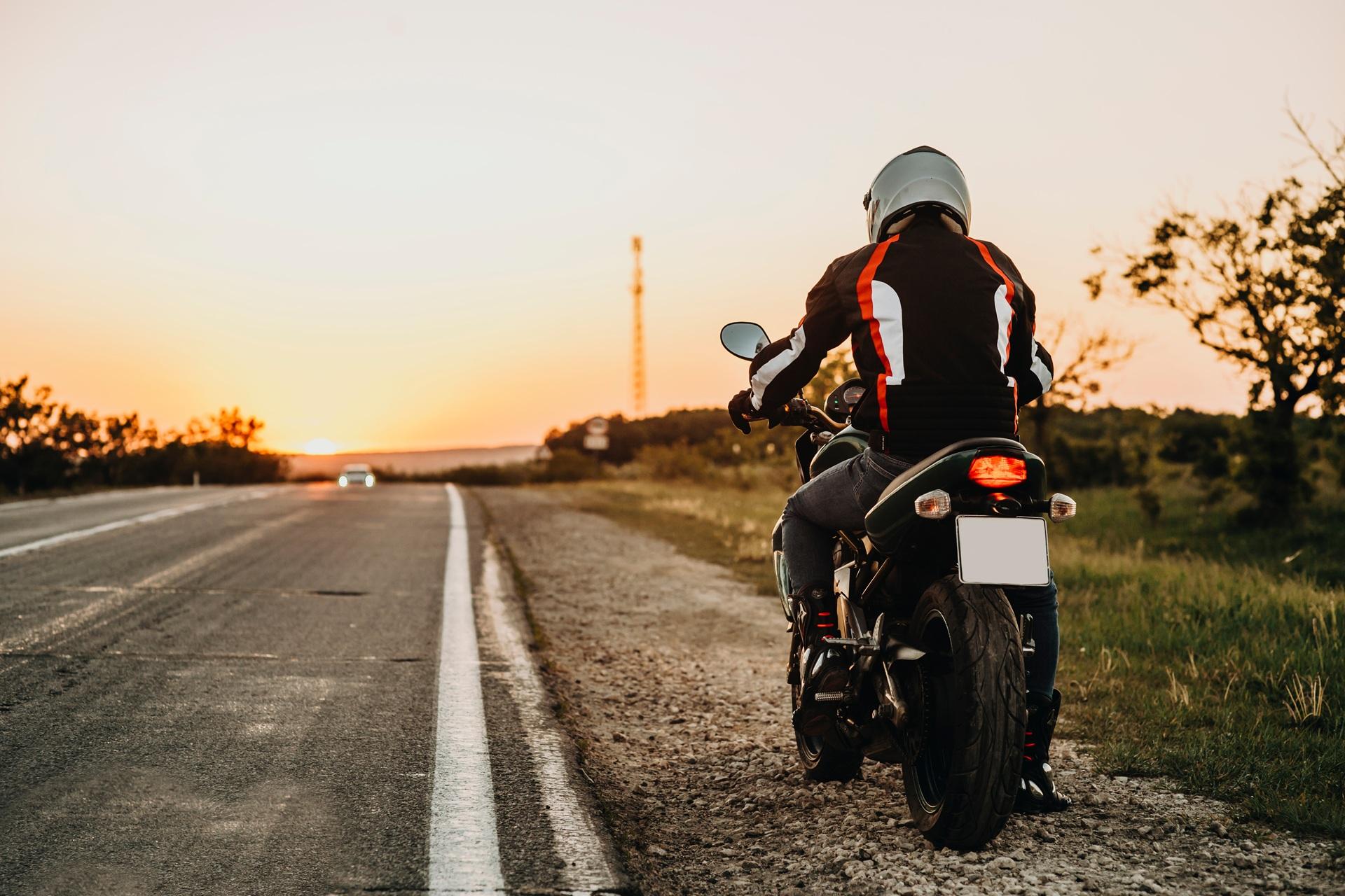 Motorradfahrer an Landstraße bei Sonnenuntergang | Tankrucksäcke

