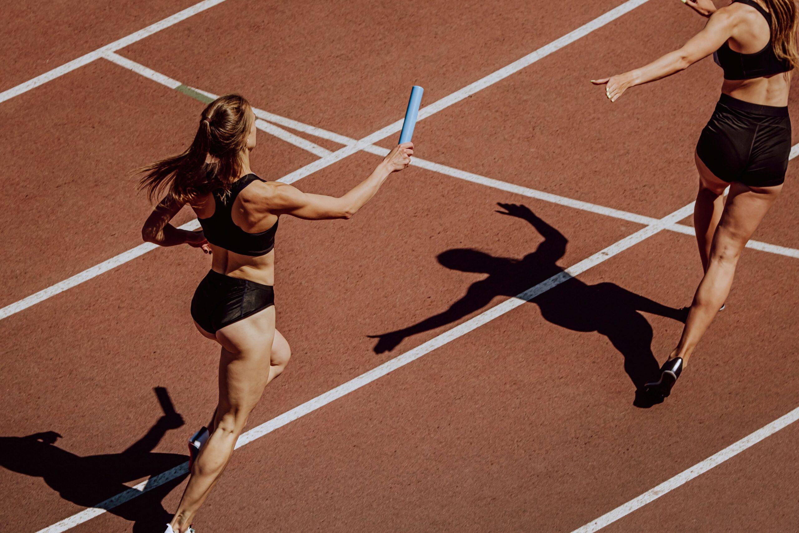 Staffelübergabe im Laufwettbewerb – Symbol für Teamarbeit und fairen sportlichen Wettbewerb