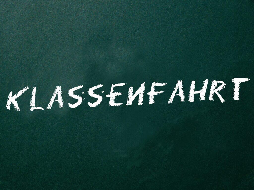 Wort Klassenfahrt steht gross auf einer Tafel | Klassenfahrt Berlin