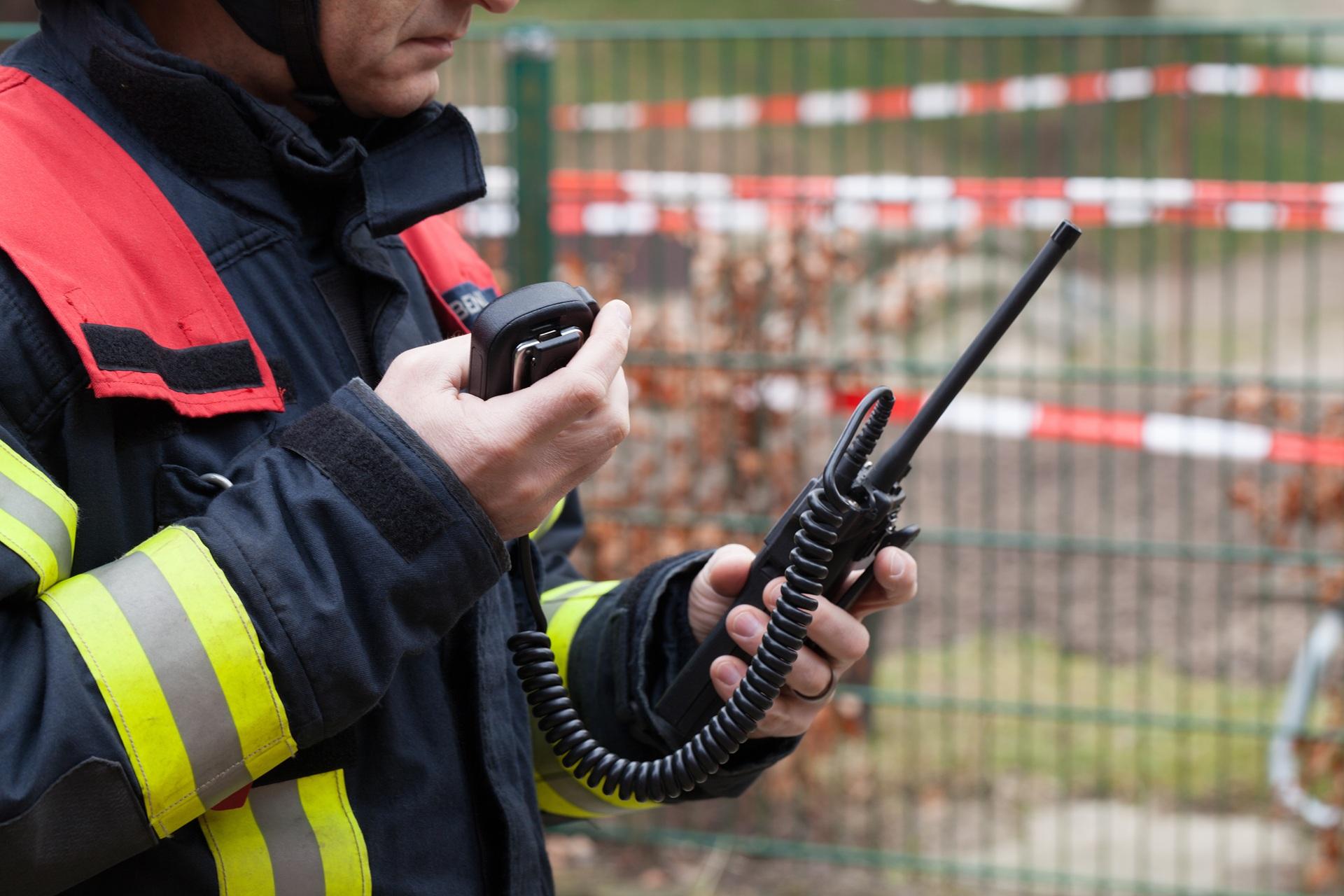 Einsatzkraft mit Funkgerät bei Sicherheitsabsperrung | Brandwache München