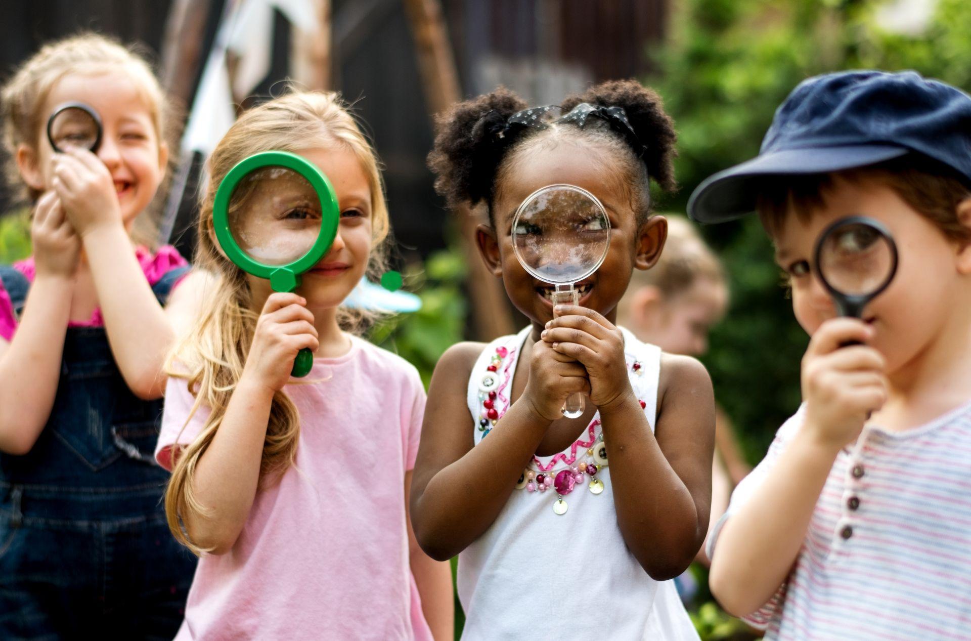 Kinder erkunden spielerisch den Garten mit Lupen im Kindergarten Schwabing