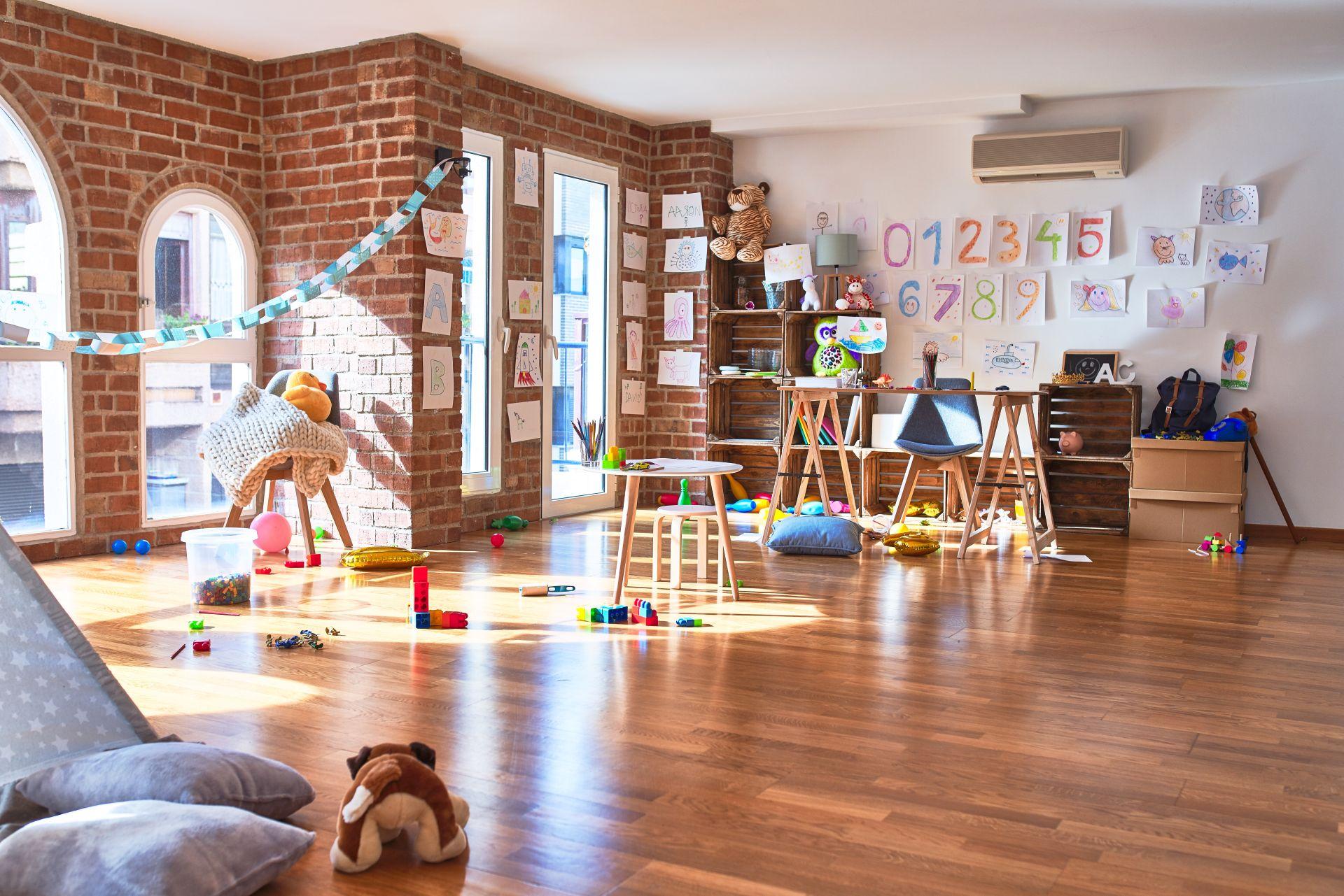 Freundlicher heller Gruppenraum mit Spielsachen und Bastelarbeiten im Kindergarten Schwabing