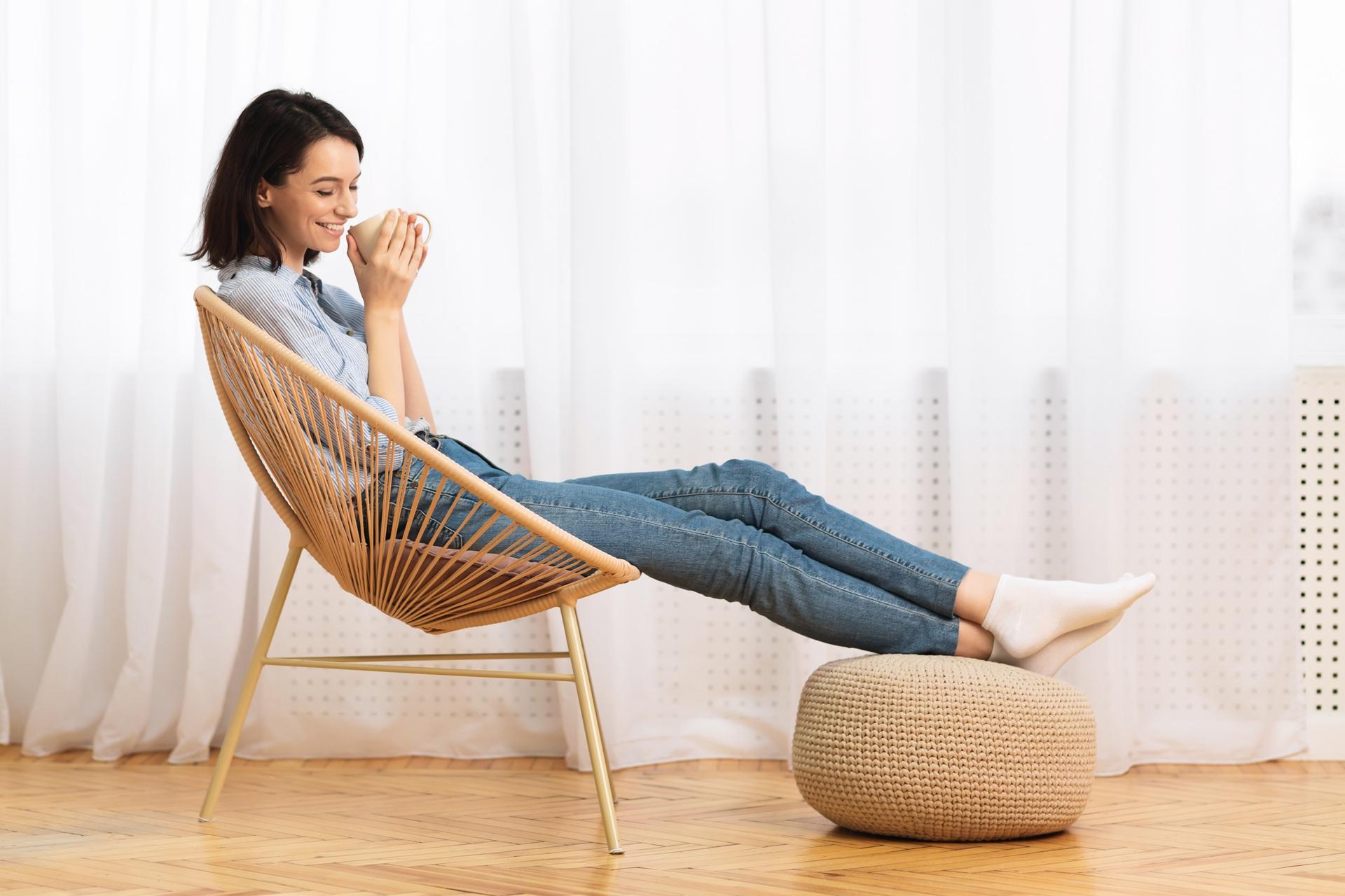 Frau geniesst Kaffee im Korbsessel | Garten Pool