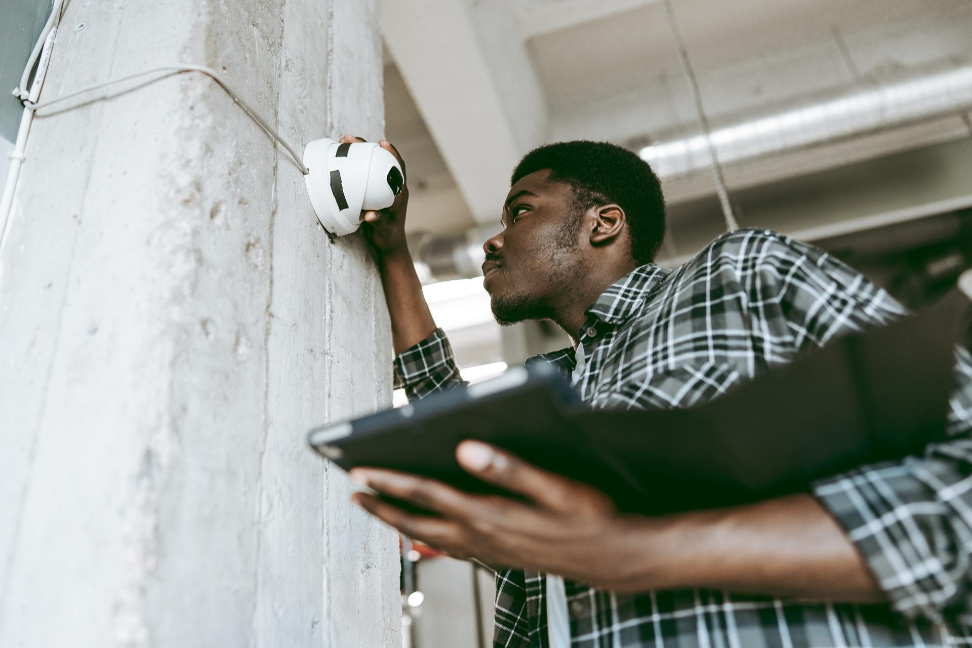 Techniker prüft installierten Sicherheitssensor an Wand | Nasssauger Industrie